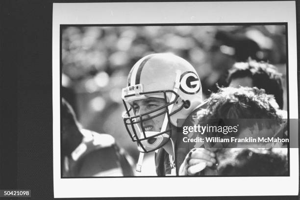 Green Bay Packers offensive lineman Tony Mandarich in uniform, sitting on sidelines w. Others during football game.