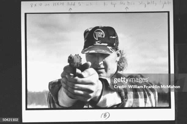 Green Bay Packers offensive lineman Tony Mandarich, sporting hunting clothes, shooting pistol outside at range. Near green bay.