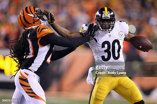 Jordan Todman of the Pittsburgh Steelers stiff arms Reggie Nelson of the Cincinnati Bengals in the first half of the AFC Wild Card Playoff game at...