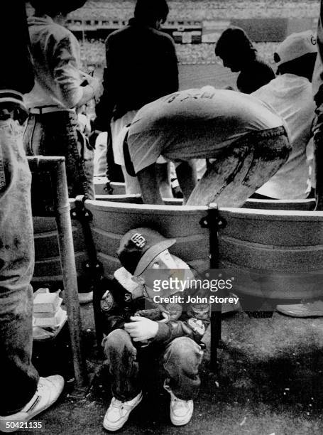 Young boy cowering behind seats at Candlestick Park after an earthquake struck the San Francisco Bay area.