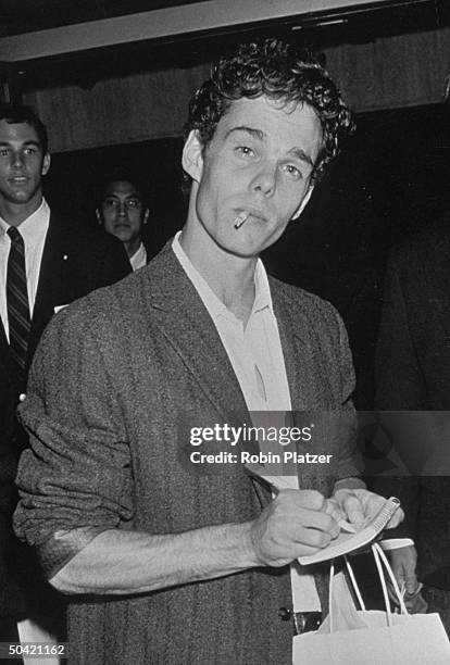 Actor Kevin Dillon, a cigarette hanging out of his mouth, signing an autograph at a benefit screening of the motion picture Immediate Family, for the...