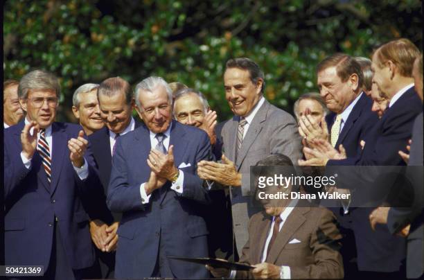 Pres. Reagan applauded by Rep. Kemp, aides Baker & Regan, Sen. Dole & Rep. Rostenkowski during Tax Reform Bill signing ceremony at WH.