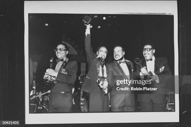 Four black members of the vocal group The Four Tops incl. Levi Stubbs , Duke Fakir, Obie Benson & Lawrence Payten, holding their awards as they pose...