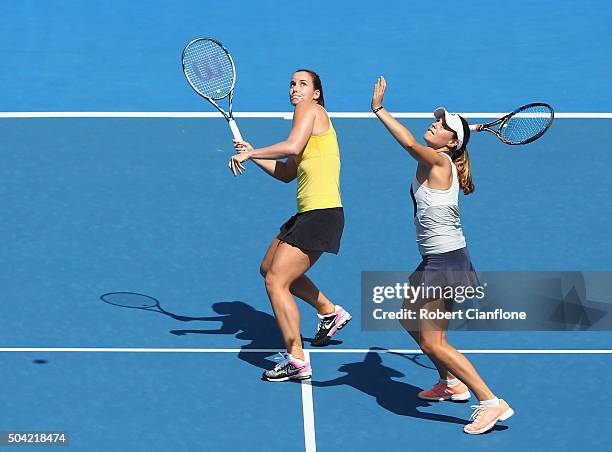 Kimberly Birrell of Australia looks to play an overhead shot as teammate Jarmila Wolfe of Australia looks on in the women's doubles match against...