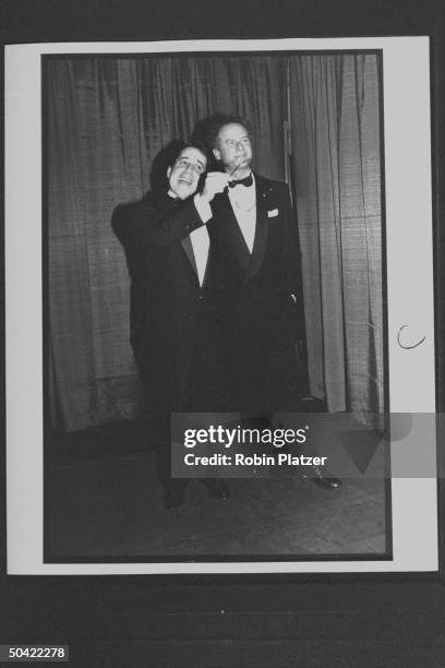 Singers Paul Simon & Art Garfunkel posing off stage during the Rock & Roll Hall of Fame induction ceremony at the Waldorf-Astoria Hotel.