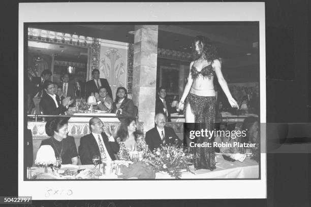 Wife of former Filipino Pres. Imelda Marcos w. Saudi arms dealer Adnan Khashoggi & his daughter Nabila & other guests, watching belly dancer Nadia...