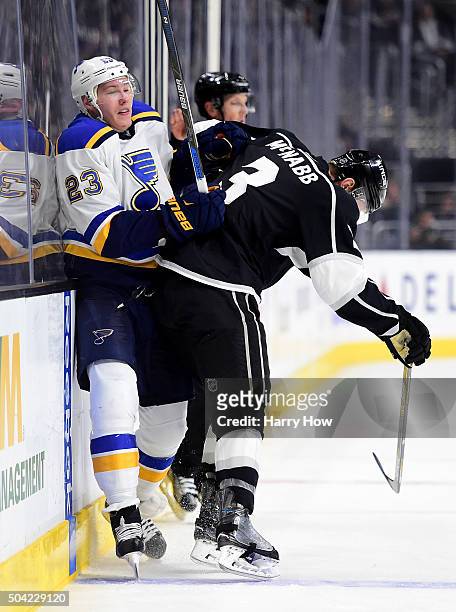Dmitrij Jaskin of the St. Louis Blues takes a check from Brayden McNabb of the Los Angeles Kings during the first period at Staples Center on January...