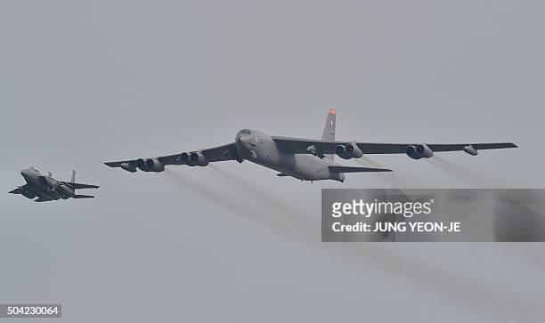 Stratofortress is escorted by a South Korean F-15K fighter jet as it flies over the Osan Air Base in Pyeongtaek, south of Seoul, on January 10, 2016....