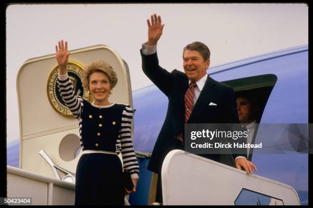Pres. & Nancy Reagan waving, poised before deplaning, arriving to fete Alf Landon on his 100th bday.