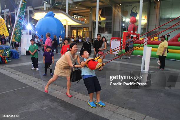 Mom and son take part in an activity of a real life Angry birds game during National Children's Day at the front of Central World. The shopping mall...