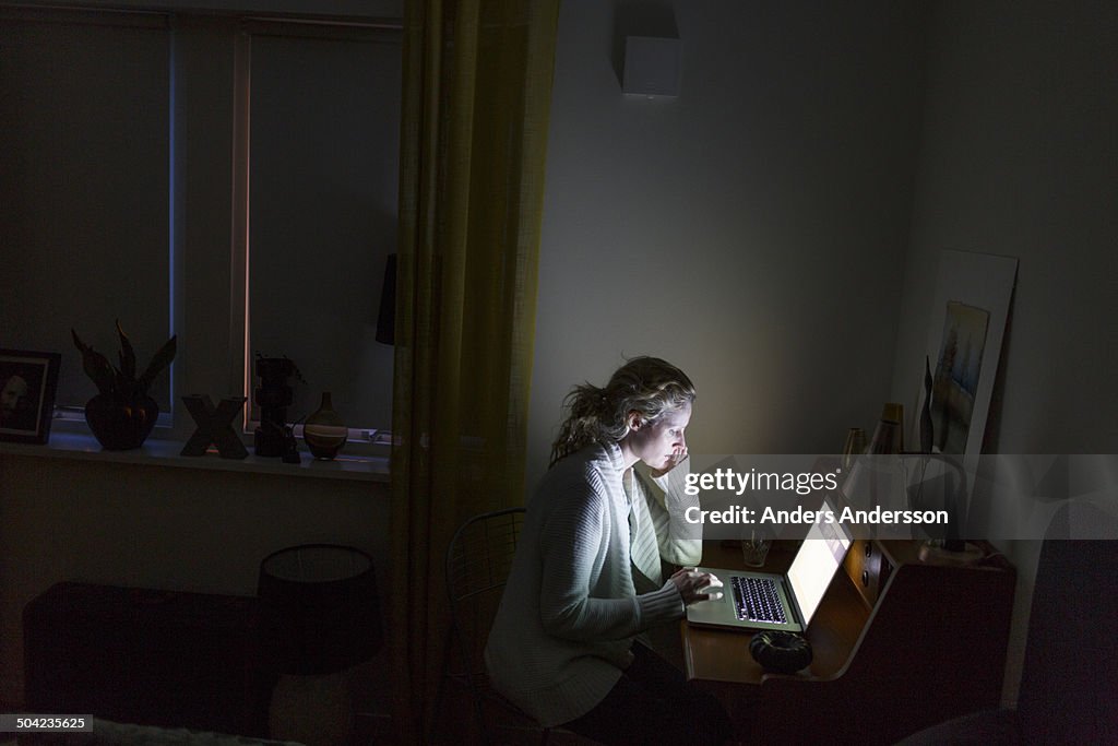 Woman by laptop at night