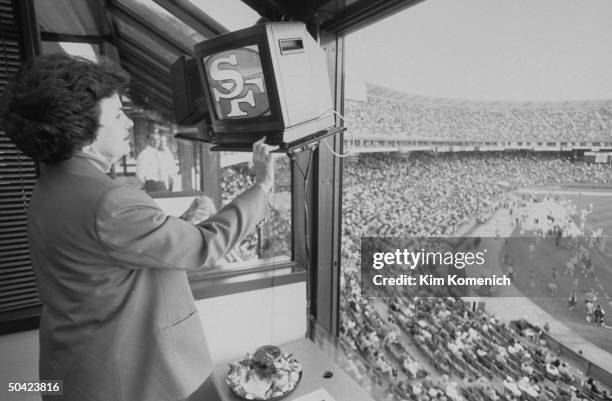 San Francisco Mayor & Dem. Gubernatorial hopeful Dianne Feinstein adjusting TV monitor in private box during NFL game between San Francisco 49ers &...