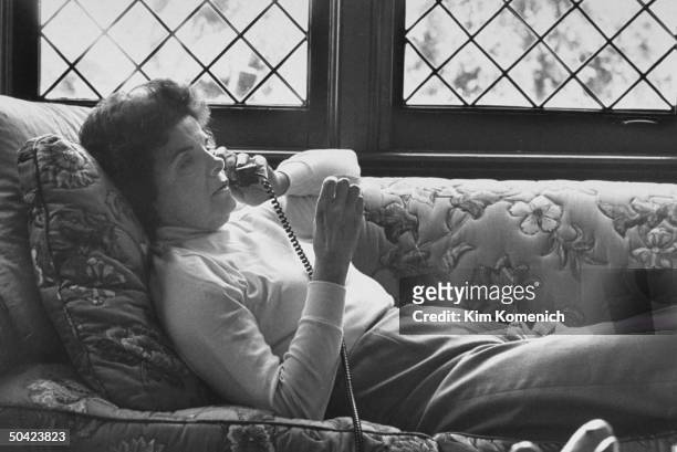 San Francisco Mayor & Dem. Gubernatorial hopeful Dianne Feinstein on telephone, lying comfortably on couch.