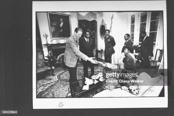 Chief of Protocol Joseph Reed greeting Congolese Pres. Denis Sassou-Nguesso & his wife Antoinette who is shaking his hand as other unident. Black men...