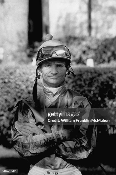 Portrait of jockey Pat Day wearing his racing silks & helmut, holding riding crop w. His arms folded across his chest in paddock at Keeneland Race...