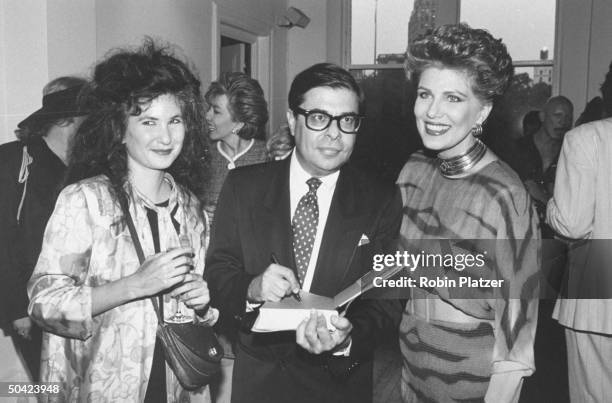 Author Bob Colacello signing his book as he stands between writer Tama Janowitz and Georgette Mosbacher , wife of Secy. Of Commerce, at book party.