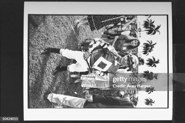 Jockey Pat Day posing resplendently in racing silks amidst others on interior of track before the Breeder's Cup race.