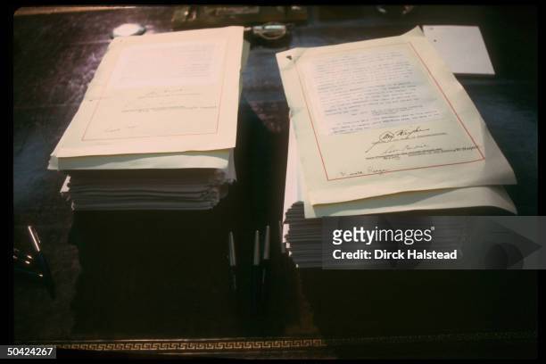 Stacked budget & reconciliation bill documents signed by Pres. Reagan, House Spkr. Wright & acting Sen. Pres. Burdick, in WH Oval Office.