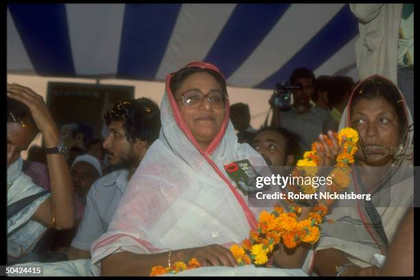 Awami League ldr. Sheik Hasina Wazed on stump, holding lei, w. Supporters during election campaign rally.