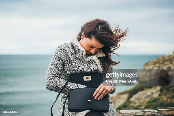 young woman searching in her purse - leather bag stock pictures, royalty-free photos & images