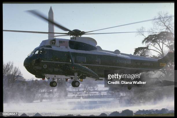 Marine One copter hovering over snowy WH lawn in front of Wash. Monument during Reagan return fr. Camp David.
