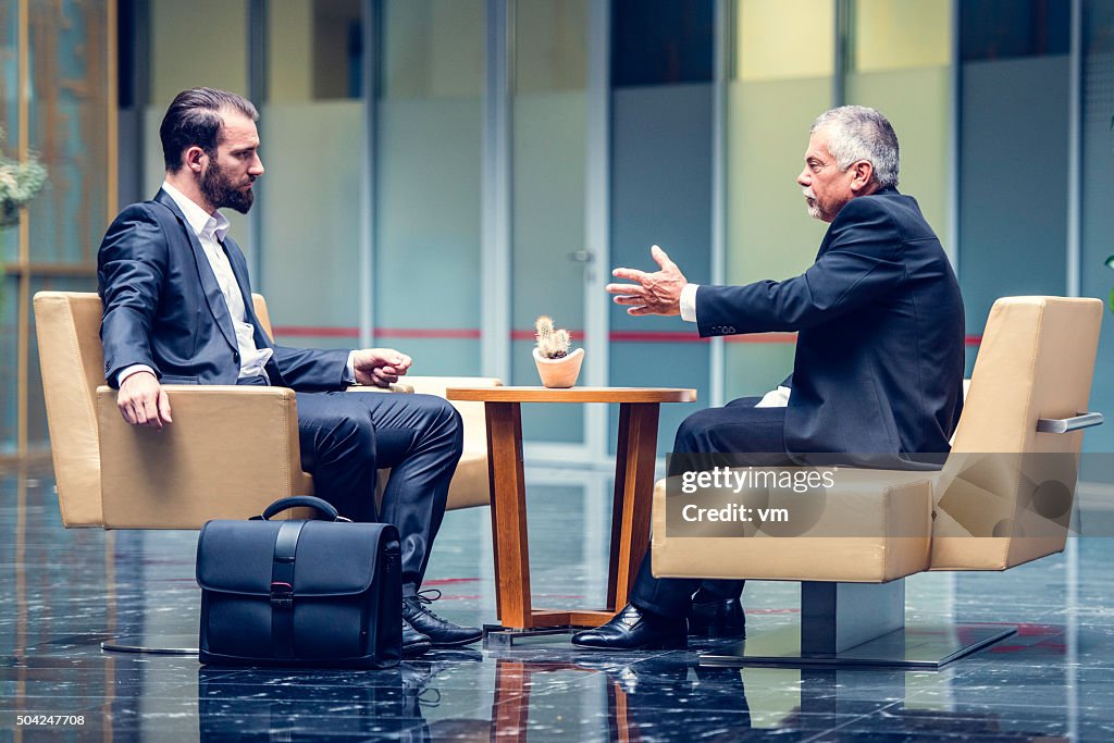 Businessmen negotiating in a modern office lobby