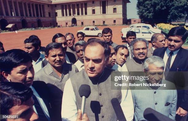 Opposition Congress Party ldr. Former PM Rajiv Gandhi , speaking to press, outside, w. Entourage in tow, during pol. Maneuvering following PM Chandra...