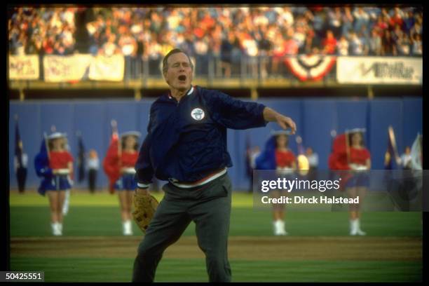 Pres. Bush indulging in high jinks, displaying great gusto, poised w. Mitt, throwing out opening ball at Rangers baseball game.