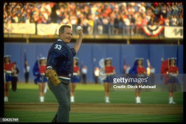 Pres. Bush indulging in high jinks, poised, w. Glove, before throwing out opening ball at Rangers baseball game.