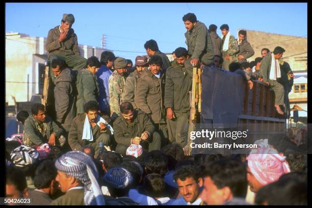 Truckload of Iraqi defector POWs amid crowd of Kurds before being sent to exile in Syria, during post-gulf war Kurdish uprising & refugee exodus....