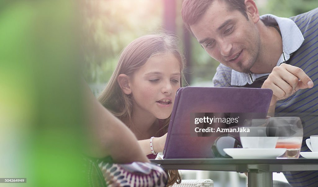 Father and daughter on digital tablet