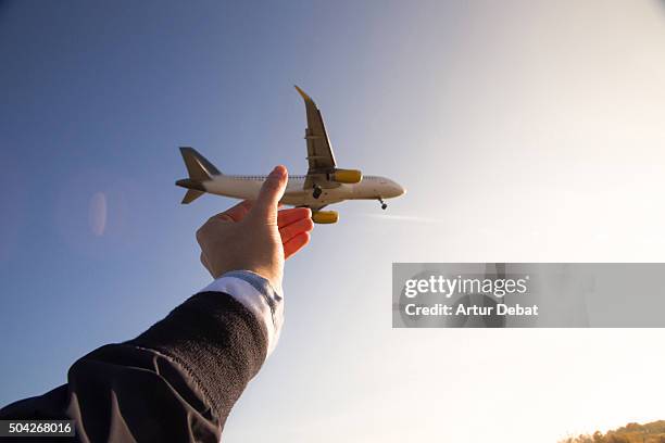 grabbing airplane in the sky, playing with the perspective from personal point of view. - diminishing perspective stock pictures, royalty-free photos & images
