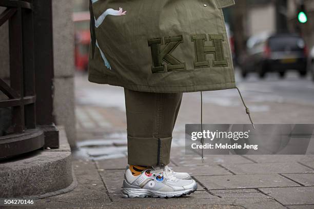 Showgoer wears a large olive Juun J parka and Raf Simons x Adidas sneakers during The London Collections Men AW16 at Victoria House on January 9,...