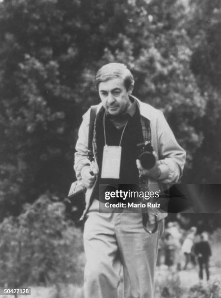 American photographer Bernard Gotfryd holds photographic equipment while travelling with Pope John Paul II, Poland, June 1983.