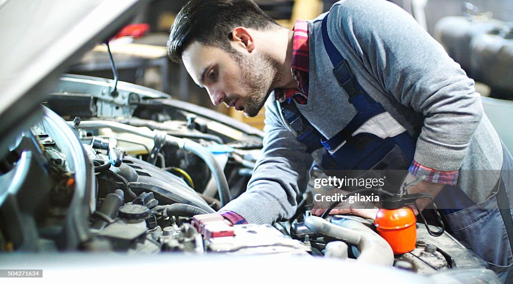 Car mechanic repair an engine.