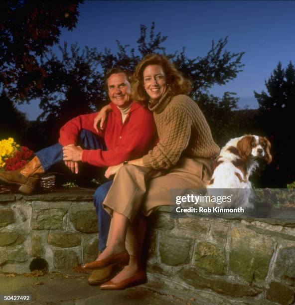 American Express CEO James Robinson w. Wife Linda & dog Ruby, sitting on wall outside their home.