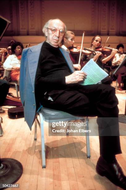 Composer Aaron Copland holding music during rehearsal at Carnegie Hall.