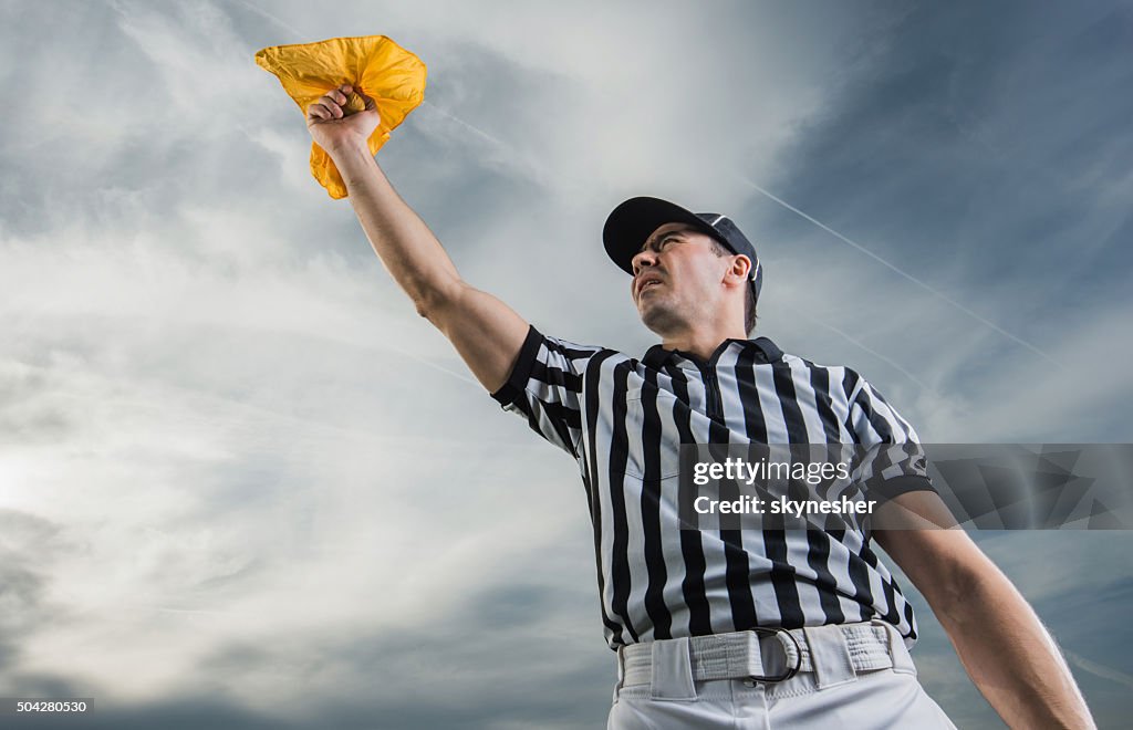 Below view of referee showing penalty against the sky.