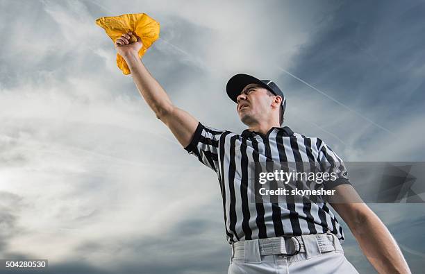 below view of referee showing penalty against the sky. - american football referee stock pictures, royalty-free photos & images