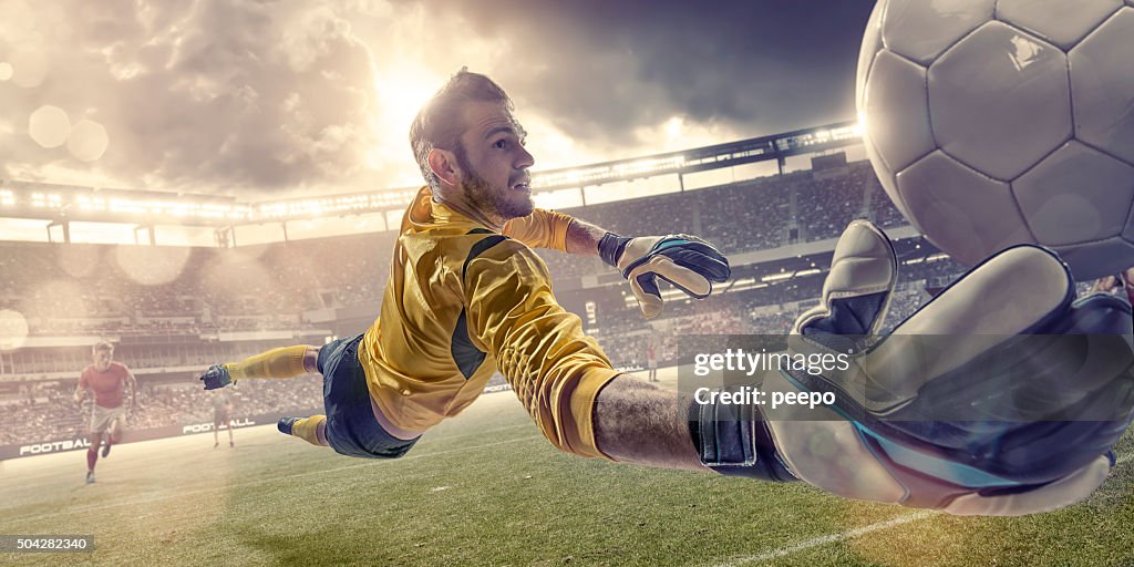Football Goalkeeper Diving To Save Ball During Soccer Match