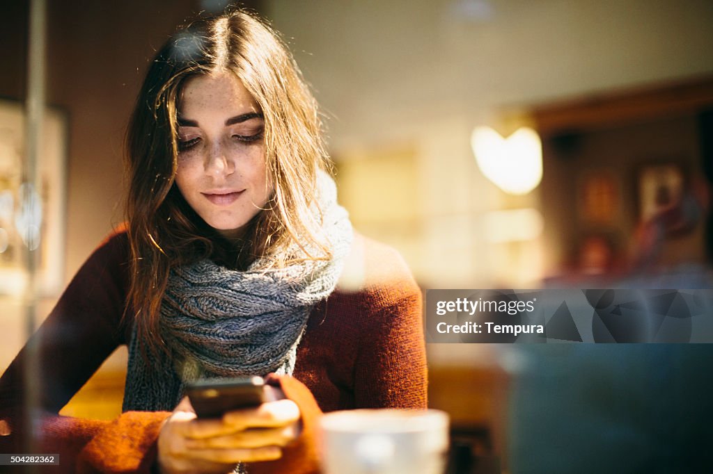 Beautiful young woman texting on smart phone.