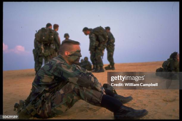 18th Airborne Corps soldiers taking breather, resting after jumping fr. Air Force C-141s, in training at drop zone at Fort Bragg.