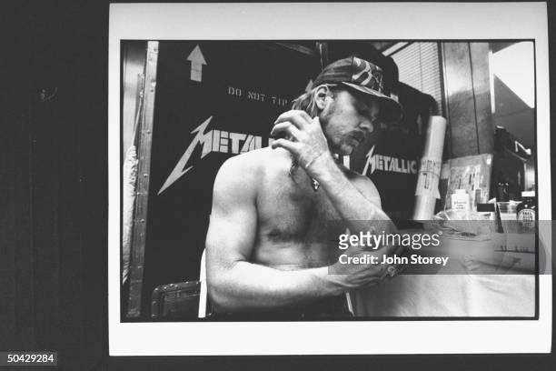 James Hetfield, lead singer and rhythm guitarist for the rock group Metallica, rubbing aloe on burns on his arm inflicted when he strayed into the...