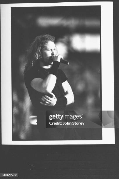 James Hetfield, lead singer and rhythm guitarist for the rock group Metallica, wearing elasticized net glove on burned left hand, as he holds hand...