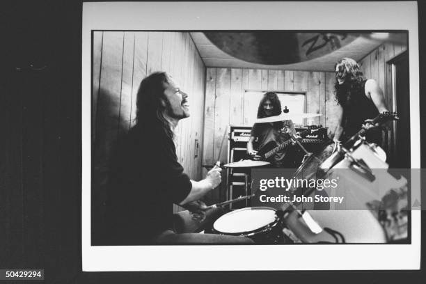 James Hetfield lead singer and rhythm guitarist for the rock group Metallica, playing drums, as he jams w. Bassist Jason Newsted and guitarist Kirk...