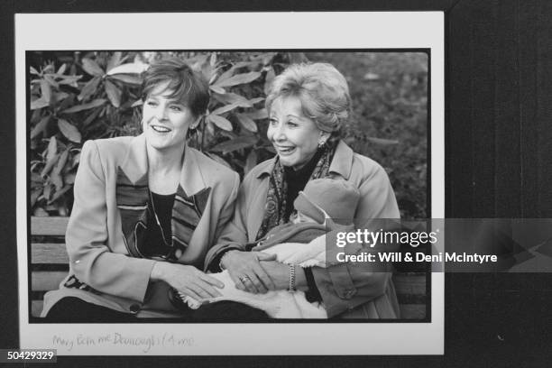 Former cast members of the TV show The Waltons Mary McDonough & Michael Learned sitting on bench as Learned holds McDonough's 4-mo-old baby, Sydnee...