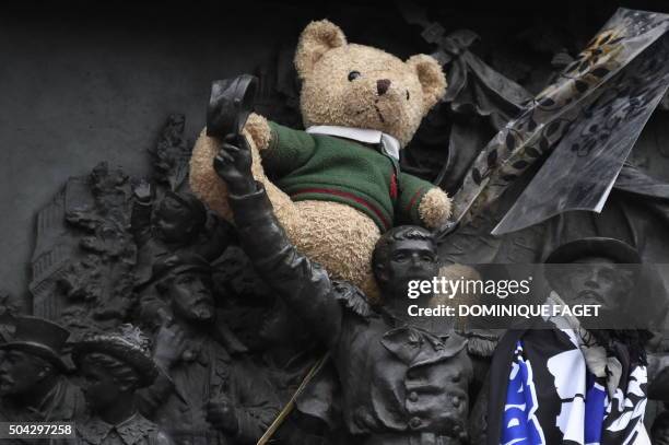 Teddy bear is lodged on the relief sculpture at the base of the statue of Marianne at Place de la Republique where a remembrance rally was held on...