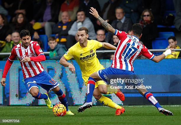 Sporting Gijon's midfielder Carlos Carmona vies with Villarreal's forward Roberto Soldado during the Spanish league football match Villarreal CF vs...