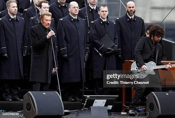 French singer Johnny Hallyday sings during a ceremony at Place de la Republique to pay tribute during a ceremony held for the victims of last year's...