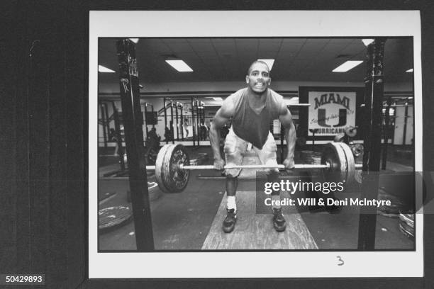 Son of the late reggae musician Bob Marley & Univ. Of Miami football player, Rohan Marley, performing deadlift w. Heavy barbell as he works out in...